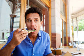 tagAlt.Older handsome man eating pizza at outdoor restaurant