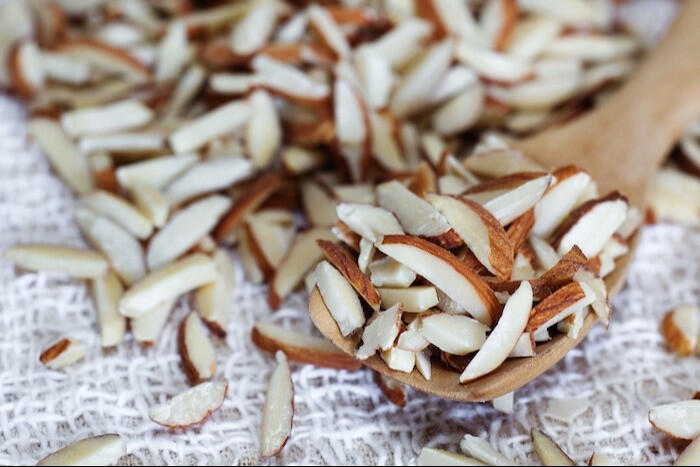 sliced almonds with a wooden spoon