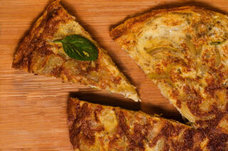 cecina sliced on wooden board with basil leaf