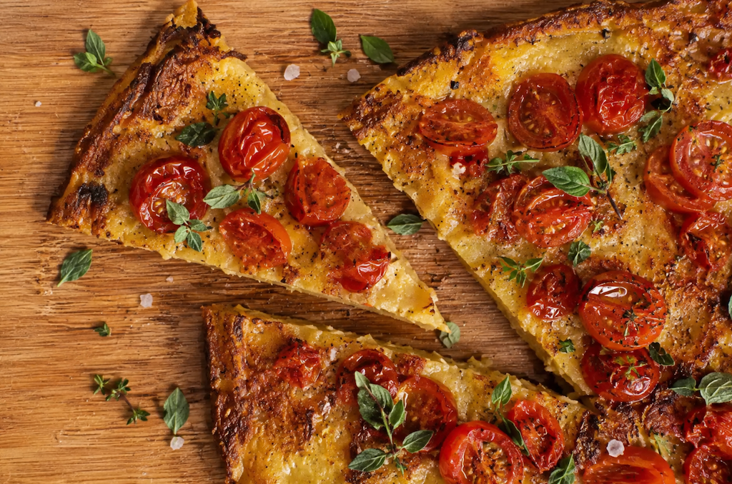 cecina sliced on wooden board with basil leaf
