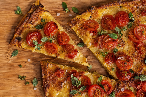 cecina sliced on wooden board with basil leaf