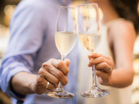a couple holding two flutes of champagne