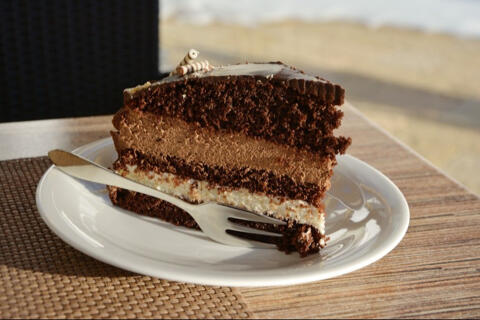 chocolate cake slice on a plate with dessert fork.
