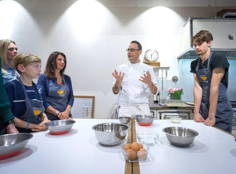 chef explains to younger group of students in cooking class