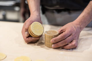 demonstrating corzetti pasta making with wooden stamps