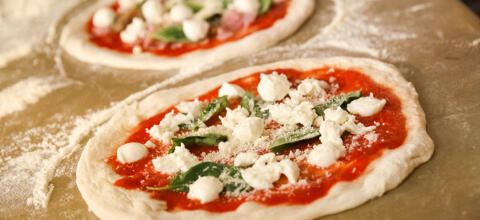fresh pizzas prepared with tomato basil parmesan and mozzarella