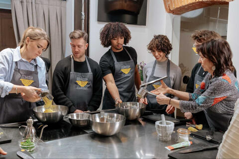 Group of cooking class students collaborating in the kitchen