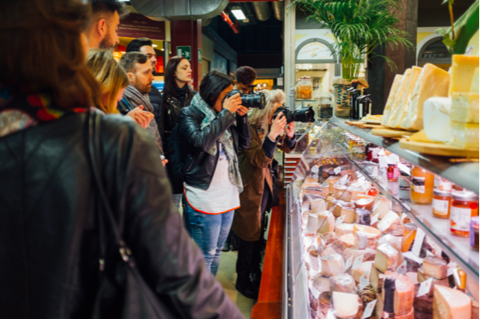 group of people looking at cheese counter in florence