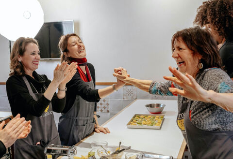 three women laughing and celebrating in cooking class