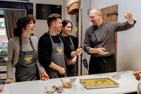 students laugh at chef holding tortelli in hand
