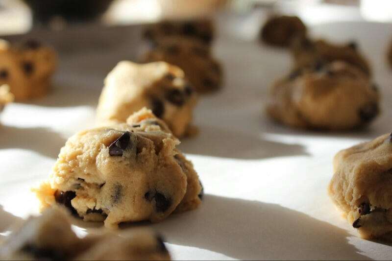 raw chocolate chip cookie dough balls on a baking sheet
