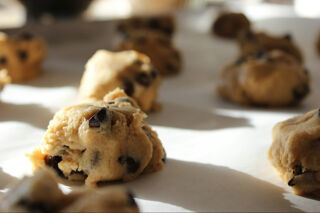 raw chocolate chip cookie dough balls on a baking sheet
