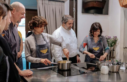 students chopping and stirring in kitchen with chef observing