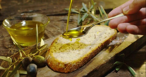 pouring olive oil on to bread with spoon