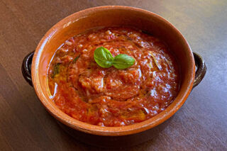 pappa al pomodoro served with basil on a table.