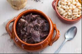 Peposo stew served in bowl with cannellini beans.