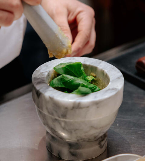 marble pestle and mortar with fresh basil and garlic
