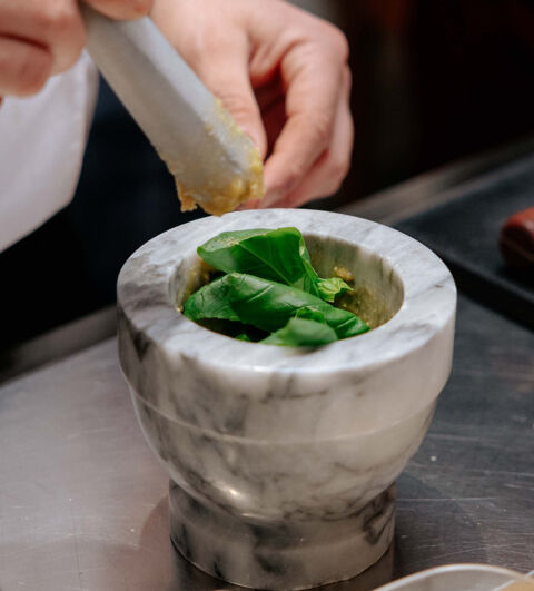marble pestle and mortar with fresh basil and garlic
