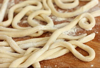 raw pici pasta dusted with flour