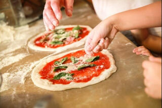 hands preparing margherita pizza
