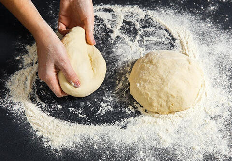 hands making pizza dough