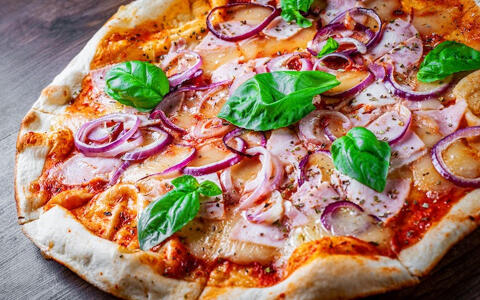 homemade pizza with red onion sausage and basil