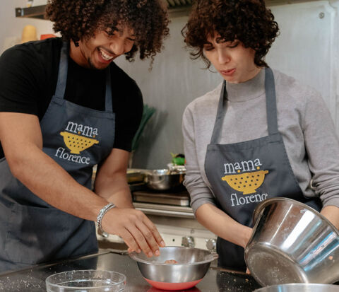 smiling couple cooking together in kitchen
