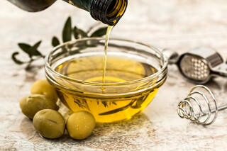 pouring olive oil into serving bowl