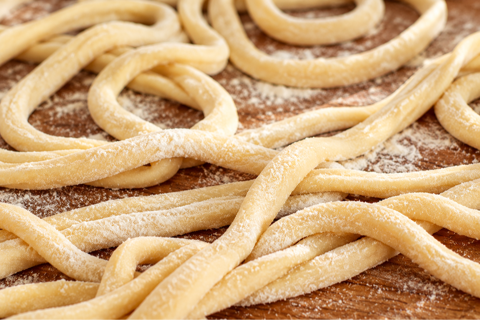 raw pici pasta dusted with flour
