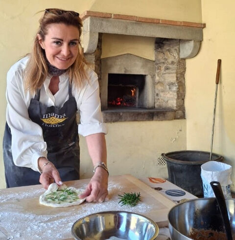 chef preparing bread aside a wood fired oven