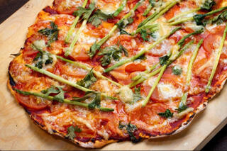 pizza with green herbs cheese and tomato