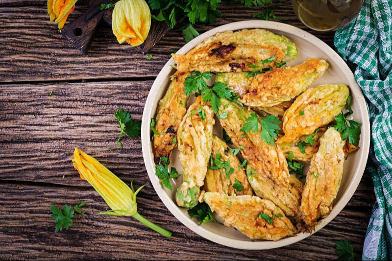 fried and stuffed zucchini flowers served in a bowl