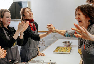 three women laughing together in kitchen