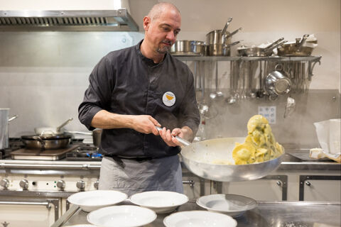 chef tossing tortelli in a sauce pan