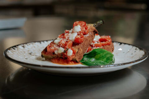 baked eggplant served with tomato mozzarella and basil on a plate