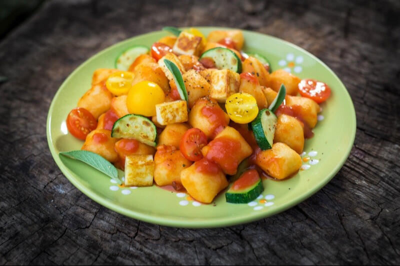 potato gnocchi served with tomato and zucchini