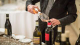 Sommelier serving wine into a glass